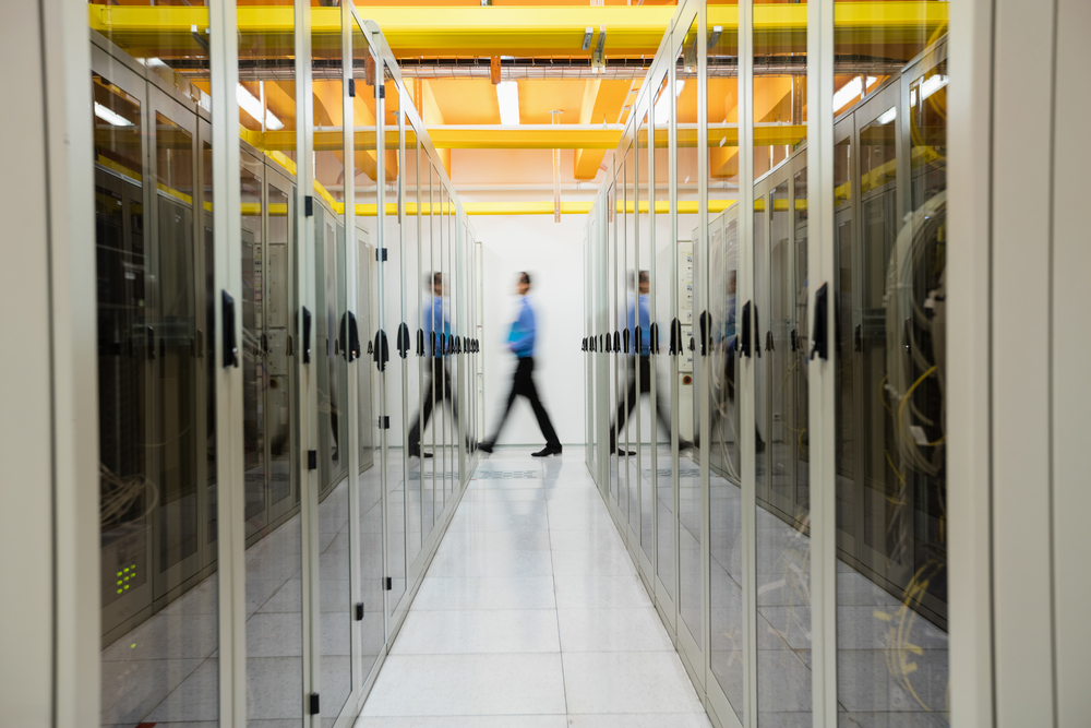 Technician walking in hallway of server room-1