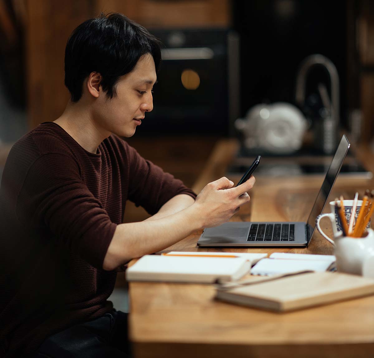 asian-man-using-smartphone-while-working-at-home-2023-02-09-00-08-14-utc